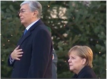 Меркель слушала гимн Казахстана сидя. Правила этикета позволяют